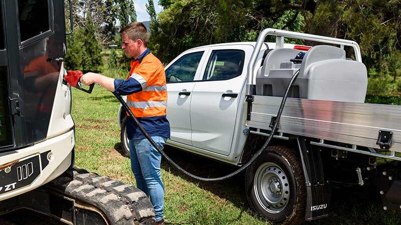Person refuelling a tractor using a Rapid Spray Genius diesel fuel pod mounted on the back of a ute