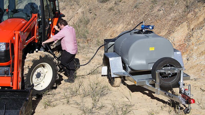 Person refuelling a tractor using a Rapid Spray diesel tank trailer for efficient on-farm fuel transfer