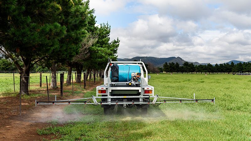 Rapid Spray Ultimate Field Sprayer mounted on a ute with a boom sprayer attachment applying spray treatment across a rural field in Australia.