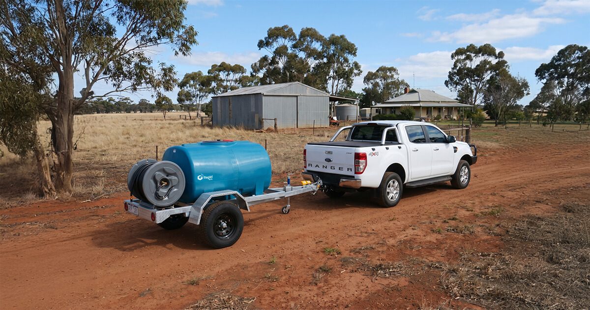 White Ford Ranger towing a Rapid Spray water trailer across a rural paddock in Australia